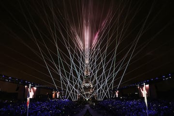 La estrella canadiense, Celine Dion, actúa en la Torre Eiffel en medio de un espectáculo de luces que salen de la imponente estructura con los anillos olímpicos  iluminados.