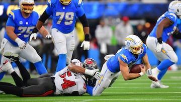 Dec 15, 2024; Inglewood, California, USA; Los Angeles Chargers quarterback Justin Herbert (10) is brought down by Tampa Bay Buccaneers linebacker Lavonte David (54) and defensive end Logan Hall (90) during the second half at SoFi Stadium. Mandatory Credit: Gary A. Vasquez-Imagn Images