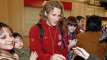 <b>CALUROSO. </b>Un centenar de hinchas recibió al Atleti en Pamplona. Forlán y Raúl García, que pese a ser baja también viajó, fueron los más requeridos.