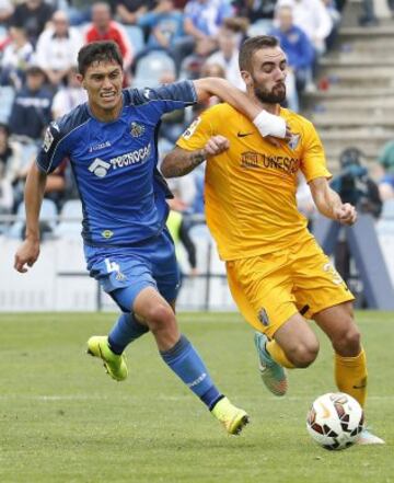 El defensa argentino del Getafe, Emiliano Velázquez, persigue al centrocampista del Málaga, Sergi Darder, durante el partido de Liga de Primera División que los dos equipos disputan en el Coliseum Alfonso Pérez, en Getafe.