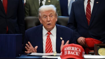 U.S. President Donald Trump sits at his desk, behind a hat that reads "America is back" at the White House in Washington, D.C., U.S., February 3, 2026. REUTERS/Evelyn Hockstein
