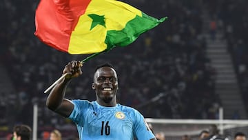 Senegal's goalkeeper Edouard Mendy waves a Senegalese flag as he celebrates after winning the Africa Cup of Nations (CAN) 2021 final football match between Senegal and Egypt at Stade d'Olembe in Yaounde on February 6, 2022. (Photo by CHARLY TRIBALLEAU / AFP)