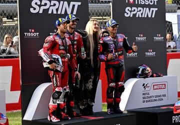 Los tres pilotos que lograron el podio en la carrera al esprint, Francesco Bagnaia, Enea Bastianini y Jorge Martín, celebran sus posiciones con la cantante Lola Índigo en el podio.