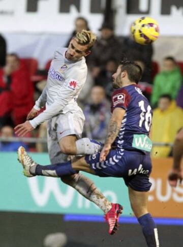 El delantero francés del Atlético de Madrid Antoine Griezmann lucha un balón con el defensa del Eibar Manuel Castellano "Lillo", durante el partido de la vigésimo primera jornada de Liga de Primera División 