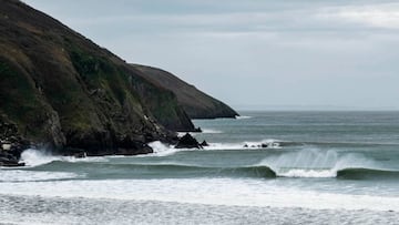 Una ola rompe frente a unos acantilados en North Devon (Inglaterra, Reino Unido).