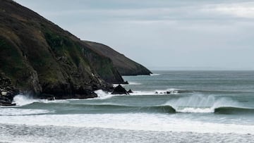 Una ola rompe frente a unos acantilados en North Devon (Inglaterra, Reino Unido).