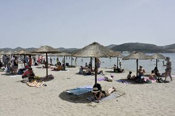 Usuarios tomando el sol en las sombrillas organizadas en la playa de Anavisos