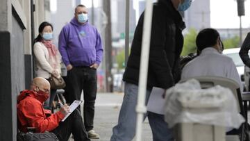 Sábado, 16 de mayo de 2020. Glen Buhlmann, abajo a la izquierda, llena una solicitud de empleo durante una feria de trabajo en Seattle.