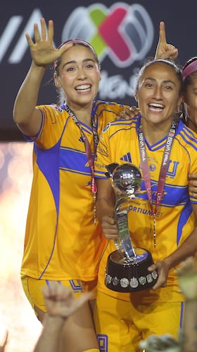 Tigres' defender #04 Greta Espinoza, forward #09 Stephany Mayor and defender #15 Cristina Ferral celebrate with the trophy after winning the Liga MX Femenil Apertura final second leg football match between Tigres and America at the Universitario Stadium in Monterrey, Nuevo Leon state, Mexico on November 23, 2025. (Photo by Julio Cesar AGUILAR / AFP)