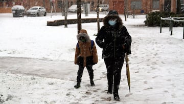 Una mujer y un niño caminan por una calle nevada este jueves en Ciudad Real donde desde las 2:30 horas se han registrado importantes precipitaciones en forma de nieve. EFE/Beldad