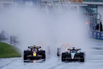 La lluvia, protagonista en la salida. En la imagen, George Russell y  Max Verstappen, en cabeza de carrera, dejan una estela de agua sobre el asfalto mojado.