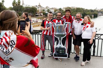 Julio Salinas posa con unos seguidores del Athletic que portan una réplica en cartón de la Copa del Rey.
