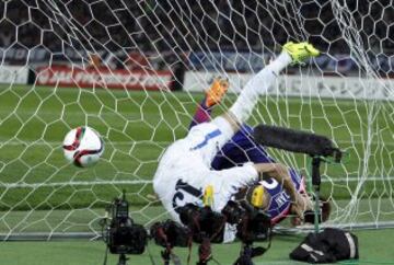 Shinji Okazaki y Lutfulla Turaev buceo enredados en la red durante el partido internacional amistoso de fútbol en Tokio 31 de marzo 2015.