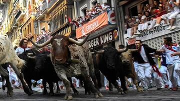 Participants run next to Fuente Ymbro fighting bulls on the fourth bullrun of the San Fermin festival in Pamplona, northern Spain on July 10, 2018.
 Each day at 8am hundreds of people race with six bulls, charging along a winding, 848.6-metre (more than h