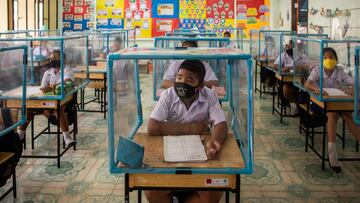BANGKOK, THAILAND - AUGUST 10: Thai students wear face masks and sit at desks with plastic screens used for social distancing at the Wat Khlong Toey School on August 10, 2020 in Bangkok, Thailand. In the beginning of July The Wat Khlong Toey School reopened its doors to its approximately 250 students following the relaxation of lockdown measures during the COVID-19 pandemic. When the school was forced to shutter its doors in mid March due to Thailand's emergency decree and lockdown, the administration and teachers prepared measures to ensure a safe reopening. By installing sinks and soap dispensers outside of each classroom, creating social distancing screens in classrooms and lunch areas and installing hand sanitizer and temperature scanners at the entry the Wat Khlong Toey school has been open for a month and has had zero cases of COVID-19. Although Thailand is now allowing schools throughout the country to further relax safety measures, the Wat Khlong Toey school has chosen to continue strict social distancing to ensure the safety of their students and teachers. (Photo by Lauren DeCicca/Getty Images)