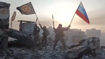 Wagner mercenary group fighters wave flags of Russia and Wagner group on the top of a building in an unidentified location in the course of Russia-Ukraine conflict, in this still image taken from video released on May 20, 2023, along with a statement by Russian mercenary chief Yevgeny Prigozhin about taking full control of the Ukrainian city of Bakhmut. Press service of "Concord"/Handout via REUTERS ATTENTION EDITORS - THIS IMAGE WAS PROVIDED BY A THIRD PARTY. NO RESALES. NO ARCHIVES. MANDATORY CREDIT.