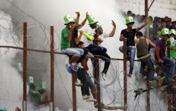 Seguidores del Khadamat Rafah subidos en una valla de alambre y espino durante el partido de la final de la Copa de Gaza contra Ittihad Shejaiya