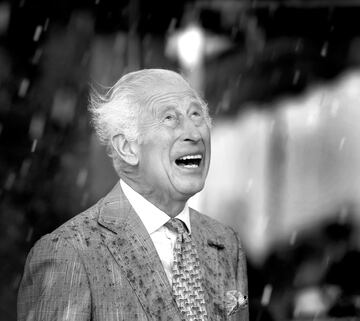 El rey Carlos III observa el desfile bajo una lluvia torrencial durante una visita oficial a Jersey el 15 de julio de 2024 en St Helier, Jersey.