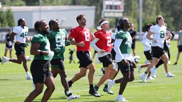 New York Jets quarterback Aaron Rodgers (8) and quarterback Zach Wilson (2) warm up with teammates during the New York Jets Training Camp at Atlantic Health Jets Training Center.