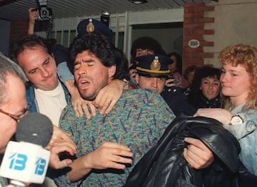 El futbolista argentino Diego Maradona es sacado por la policía de un piso de Buenos Aires, el 26 de abril de 1991, después de ser detenido por posesión de medio kilo de cocaína. 