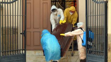 Health workers carry the coffin of a COVID-19 victim from the San Jose nursing home in Cochabamba, Bolivia, on July 20, 2020. - Ten elderly people of the San Jose nursing home died from the new coronavirus and 64 out of 100 tests done last week turned out positive. (Photo by STR / AFP)