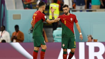 Portugal's forward #07 Cristiano Ronaldo (L) is congratulated by Portugal's midfielder #08 Bruno Fernandes (R) after scoring their team's first goal from a penalty shot during the Qatar 2022 World Cup Group H football match between Portugal and Ghana at Stadium 974 in Doha on November 24, 2022. (Photo by Khaled DESOUKI / AFP)