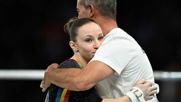 Romania's Ana Barbosu reacts with her coach after competing in the uneven bars event of the artistic gymnastics women's qualification during the Paris 2024 Olympic Games at the Bercy Arena in Paris, on July 28, 2024. (Photo by Lionel BONAVENTURE / AFP)