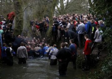 Players stand in a river as they compete for the ball during the annual Shrovetide football match in Ashbourne, Britain February 28, 2017. The aim of the teams, the Up'ards and the Down'ards, is to score by tapping the ball three times on stone goal plinths three miles apart on the banks of the River Henmore. The game dates back to the 17th century. REUTERS/Phil Noble