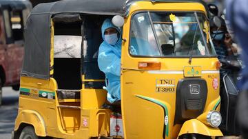 A driver wearing personal protective equipments (PPE) sits on his auto rickshaw after the government eased a nationwide lockdown imposed as a preventive measure against the COVID-19 coronavirus, in Chennai on June 2, 2020. (Photo by Arun SANKAR / AFP)