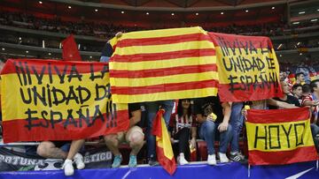 Varios aficionados portan banderas de España y Cataluña antes del comienzo del encuentro de la octava jornada de Liga de Primera División entre el Atlético de Madrid y el FC Barcelona.