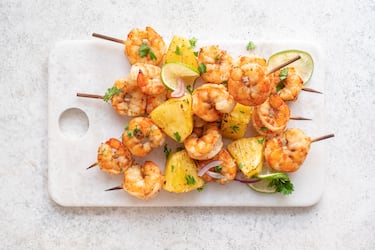 Ensarta langostinos cocidos y trozos de piña en palillos.
Pincela con salsa (soja o miel) y marca ligeramente en sartén para dar color.