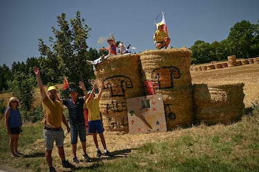 Los espectadores se alinean a lo largo del recorrido de la carrera con un objetivo de cartón improvisado para atrapar los artículos promocionales ("goodies") distribuidos por la caravana publicitaria del Tour de Francia, así como los bidones de hidratación de los ciclistas durante la sexta etapa de la 112.ª edición del Tour de Francia,  entre Bayeux y Vire Normandie.