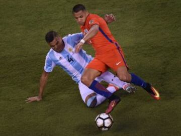 El argentino Gabriel Mercado se barre sobre el chileno Alexis Sánchez.