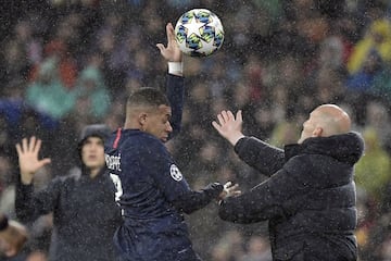 Zinedine Zidane and Kylian Mbappé tussle to get the ball in a Champions League game between Real Madrid and PSG. 