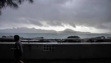 A woman jogs along the waterfront in Hong Kong amid a typhoon warning as Severe Tropical Storm Ma-on passed closest to the city in the early morning.