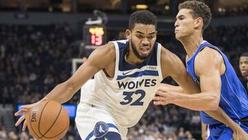 Karl-Anthony Towns trata de superar a Dwight Powell durante el partido entre los Minnesota Timberwolves y los Dallas Mavericks.