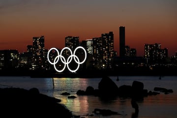 El sol se pone detrás de la instalación de los anillos olímpicos en el Parque Marino de Odaiba en Tokio, Japón.