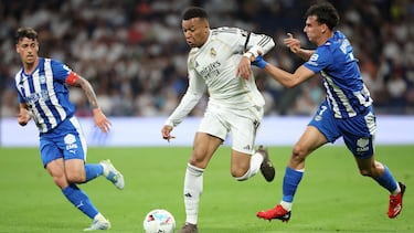Real Madrid's French forward #10 Kylian Mbappe fights for the ball with Alaves' Spanish midfielder #08 Antonio Blanco and Alaves' Spanish midfielder #07 Angel Perez during the Spanish league football match between Real Madrid CF and Deportivo Alaves at the Santiago Bernabeu stadium in Madrid on April 21, 2026. (Photo by Pierre-Philippe MARCOU / AFP)
