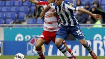 El centrocampista del Granada Iriney Santos da Silva con el defensa del Espanyol Joan Capdevila durante el partido en el estadio de Cornellá-El Prat.