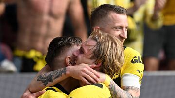 Dortmund's German midfielder Julian Brandt celebrates scoring the 0-3 goal with his teammates Dortmund's German forward Marco Reus (R) and Dortmund's German defender Nico Schlotterbeck (L) during the German first division Bundesliga football match between FC Augsburg and BVB Borussia Dortmund in Augsburg, southern Germany, on May 21, 2023. (Photo by Christof STACHE / AFP) / DFL REGULATIONS PROHIBIT ANY USE OF PHOTOGRAPHS AS IMAGE SEQUENCES AND/OR QUASI-VIDEO