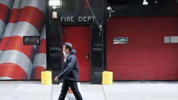 People walk by a fire house as New York City mayoral candidate Curtis Sliwa speaks to the media on November 01, 2021 in New York City.