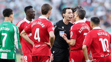 SEVILLA, 01/03/2026.- Los jugadores del Sevilla rodean al árbitro De Burgos Bengoetxea (3-d), durante el partido de LaLiga de fútbol que Real Betis y Sevilla FC disputan este domingo en el estadio de La Cartuja. EFE/José Manuel Vidal