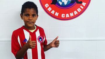 Daniel Santos Ruiz, jugador de 9 a&ntilde;os del Atl&eacute;tico Gran Canaria, posa con la camiseta y el escudo del club.