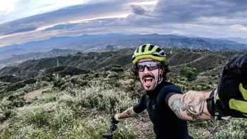 Juanma Furio se hace un selfie en el campo con la bici de MTB y el cielo nublado.