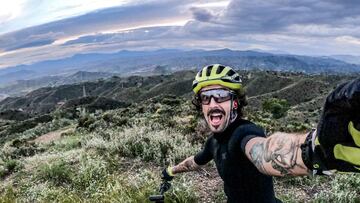 Juanma Furio se hace un selfie en el campo con la bici de MTB y el cielo nublado. 