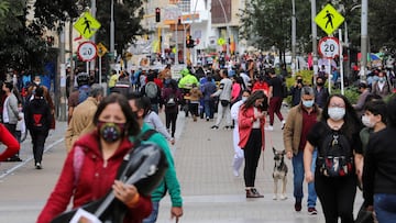 FILE PHOTO: FILE PHOTO: People wearing face masks walk down a street before the start of a mandatory total isolation decreed by the mayor's office, amidst an outbreak of the coronavirus disease (COVID-19), in Bogota, Colombia January 7, 2021. REUTERS/Luisa Gonzalez/File Photo/File Photo