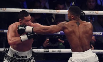 Anthony Joshua (R) of Great Britain exchanges blows with Joseph Parker (L) of New Zealand in the 12th and final round of their heavyweight unification title bout at Principality Stadium in Cardiff, March 31, 2018.  Anthony Joshua was taken the distance for the first time in his professional career before winning a unanimous points decision in his world heavyweight title unification fight with Joseph Parker.