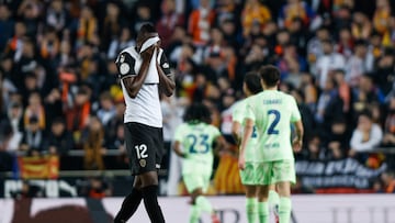 El delantero del Valencia CF Sadiq Umar tras el tercer gol del FC Barcelona durante el partido de los cuartos de final de la Copa del Rey de fútbol que Valencia CF y FC Barcelona van a disputar este jueves en el estadio de Mestalla, en Valencia. EFE/Biel Aliño