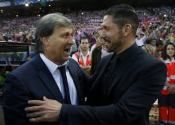 Los entrenadores del Barcelona Gerardo "Tata" Martino (i) y del Atlético de Madrid, Diego Simeone se saludan momentos antes del partido de vuelta de cuartos de final de la Liga de Campeones que se disputa esta noche en el estadio Vicente Calderón. 