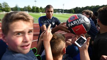Kylian Mbappé firmando autógrafos tras un entrenamiento.